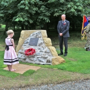 Colour photo showing the re-created corner of the now demolished Duff House east wing showing a bronze plaque and a poppy and forget-me-not wreath