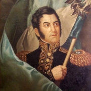 Colour photo of a distinguished General holding an Argentine flag