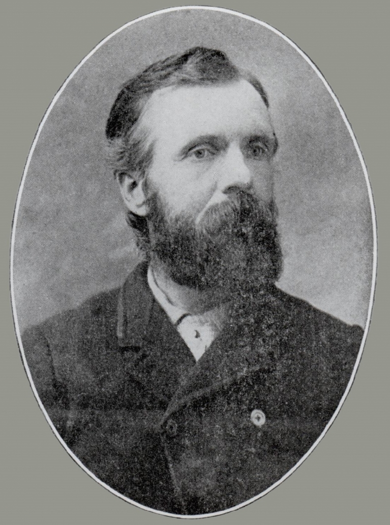 Black ad white photo of head and shoulders of bearded man